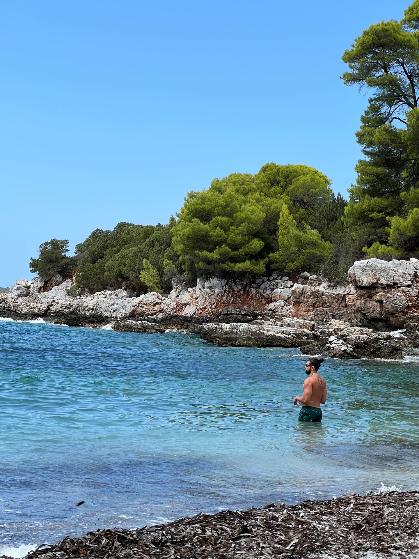 Menelaos standing in the clear water at a small cove in Northern Greece